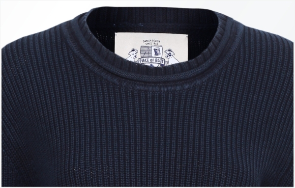 Clos up. Raised ribbing knit pullover in dark indigo blue. Piece of Blue